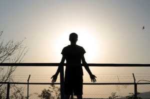 Woman looking at the sun with her arms open