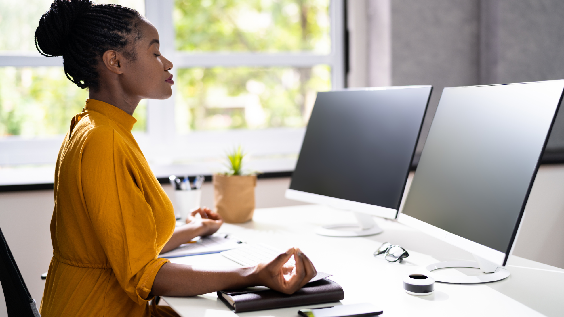 woman practicing mindfulness while working on her desk